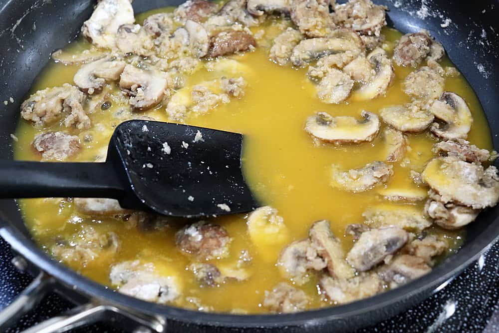 Adding broth to mushrooms
