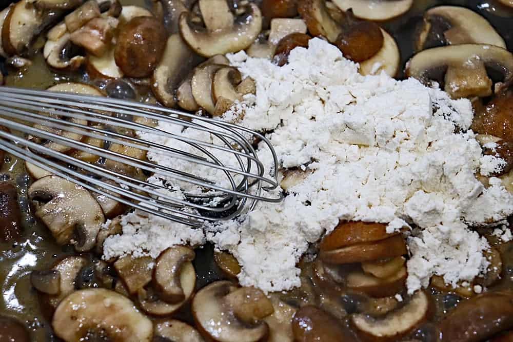Adding flour to mushrooms
