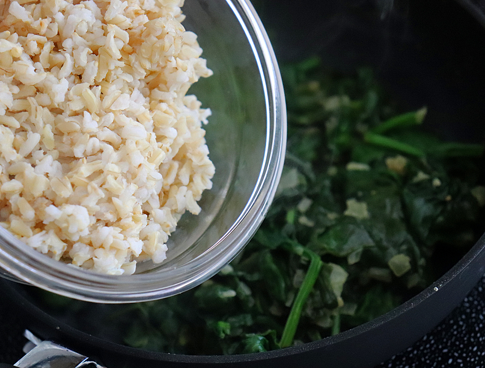 Adding brown rice to the pan