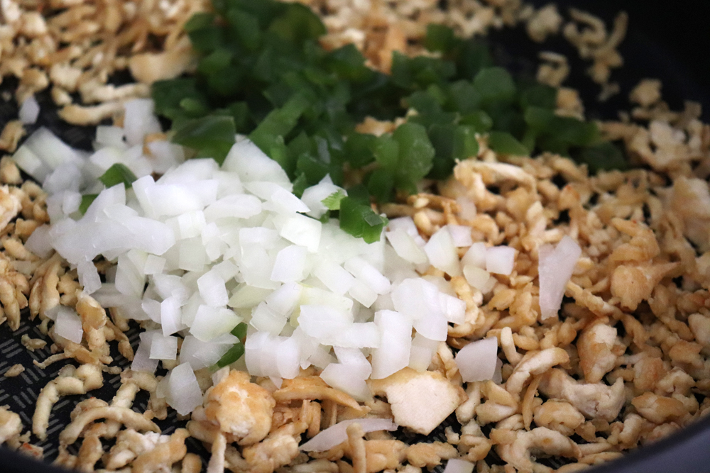 Adding Onions and Green Peppers to the Fried Tofu