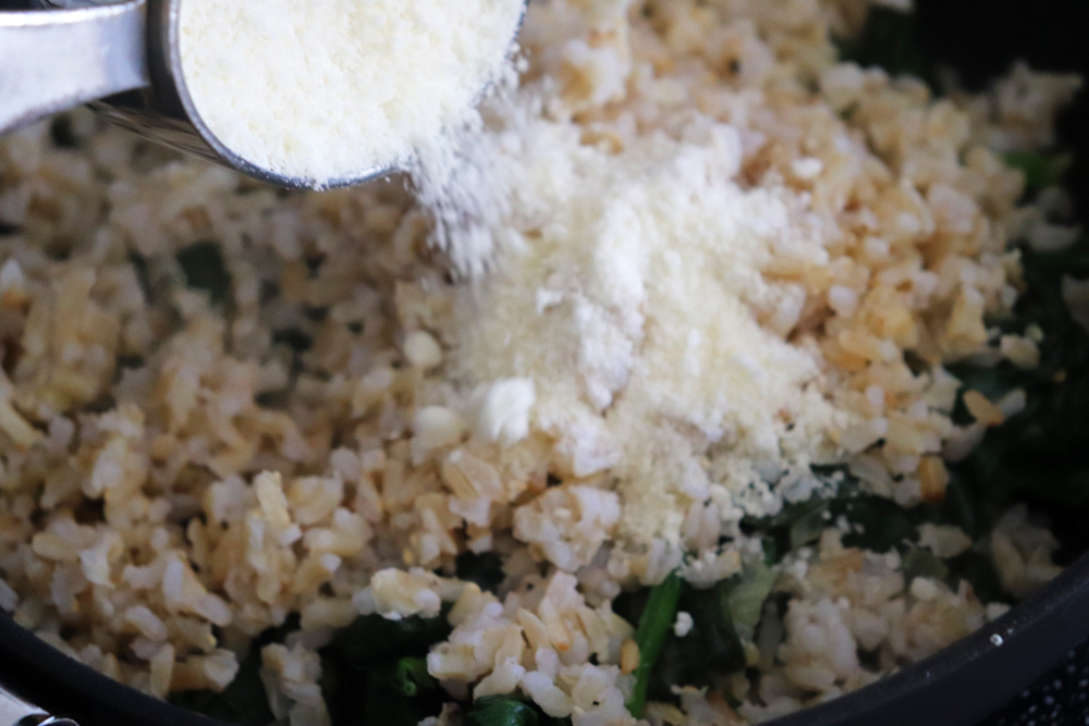 Adding vegan parmesan to the pan
