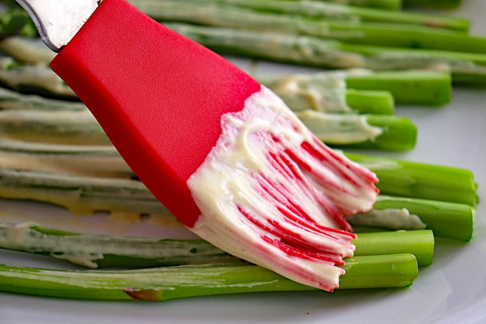 Brushing mayo mixture on asparagus