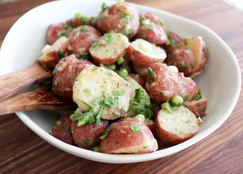 Tossed Warm Potato Salad with Dijon Vinaigrette in a white bowl
