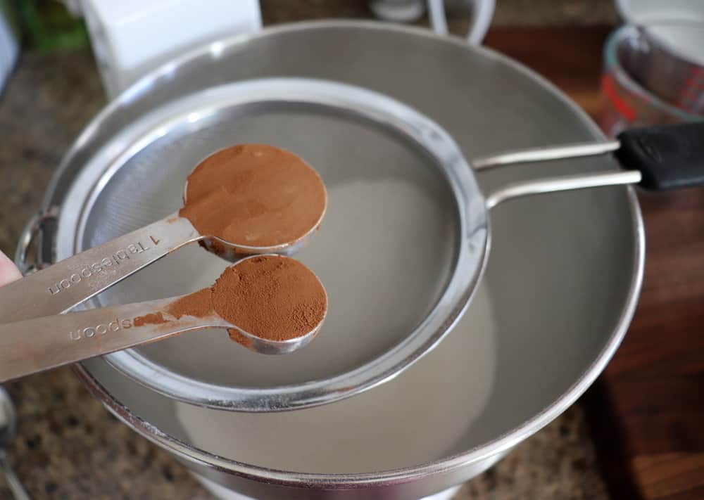 Adding cocoa powder to a strainer 