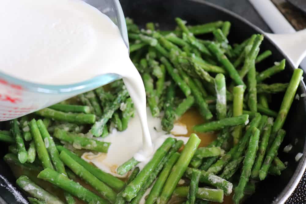Adding coconut cream to asparagus