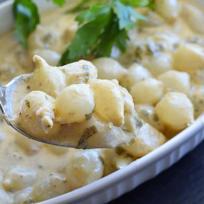 Spoon full of Easy Pearl Onions In Cream Sauce