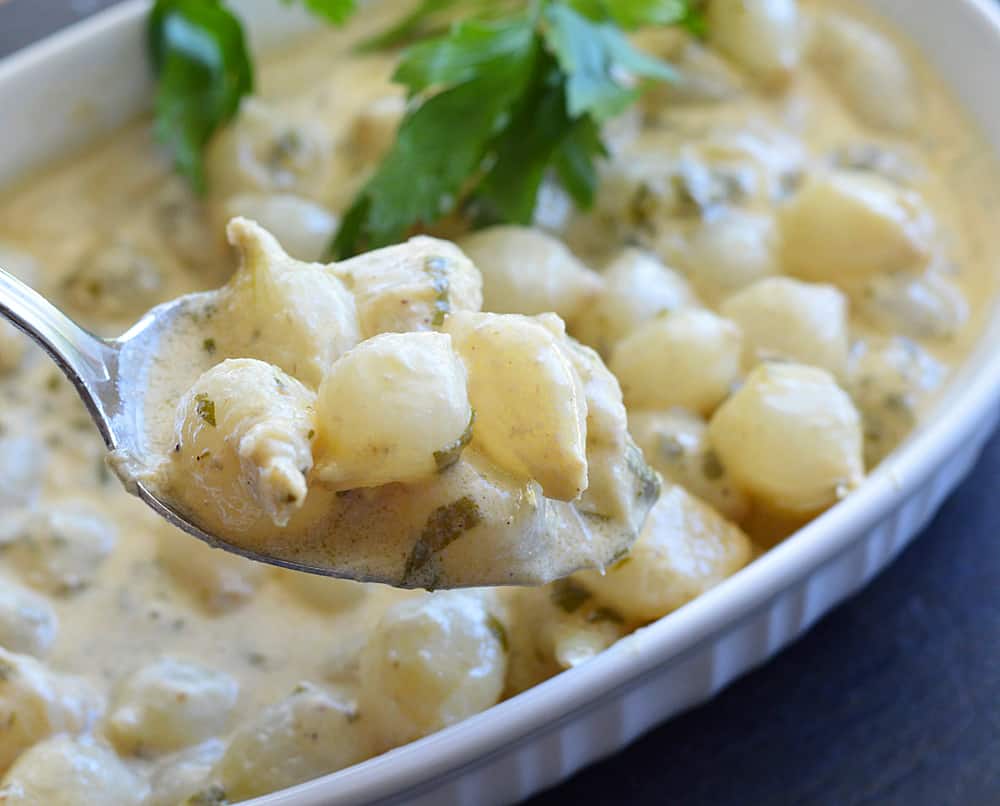 Spoon full of Easy Pearl Onions In Cream Sauce