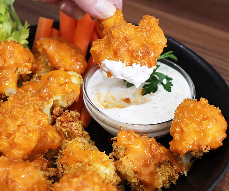 Dipping buffalo cauliflower into ranch dip