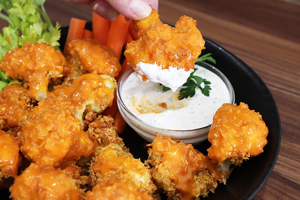 Dipping buffalo cauliflower into ranch dip