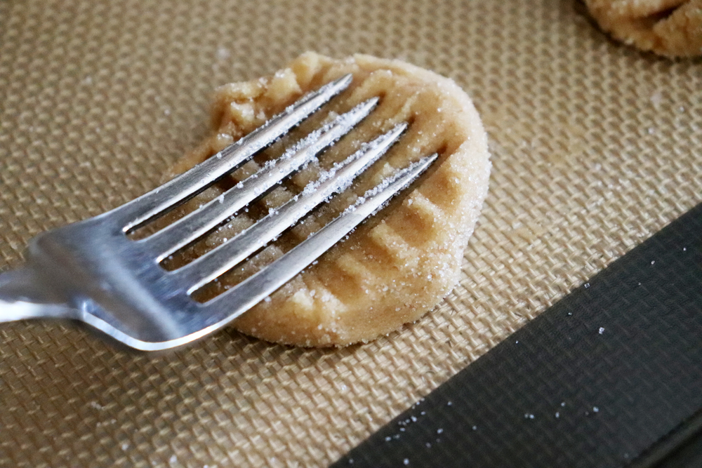 Place the sugared balls onto sheet and use fork
