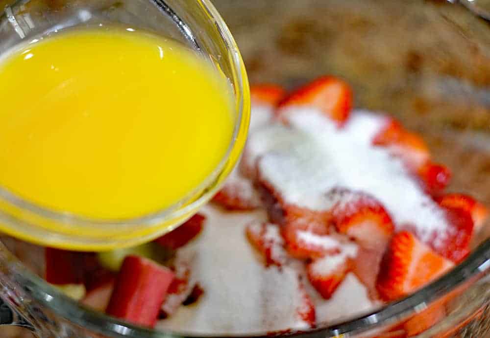 Adding orange juice to strawberries and sugar