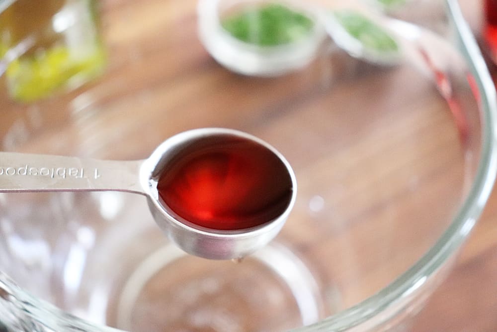 Red wine vinegar in a measuring spoon for Warm Potato Salad with Dijon Vinaigrette