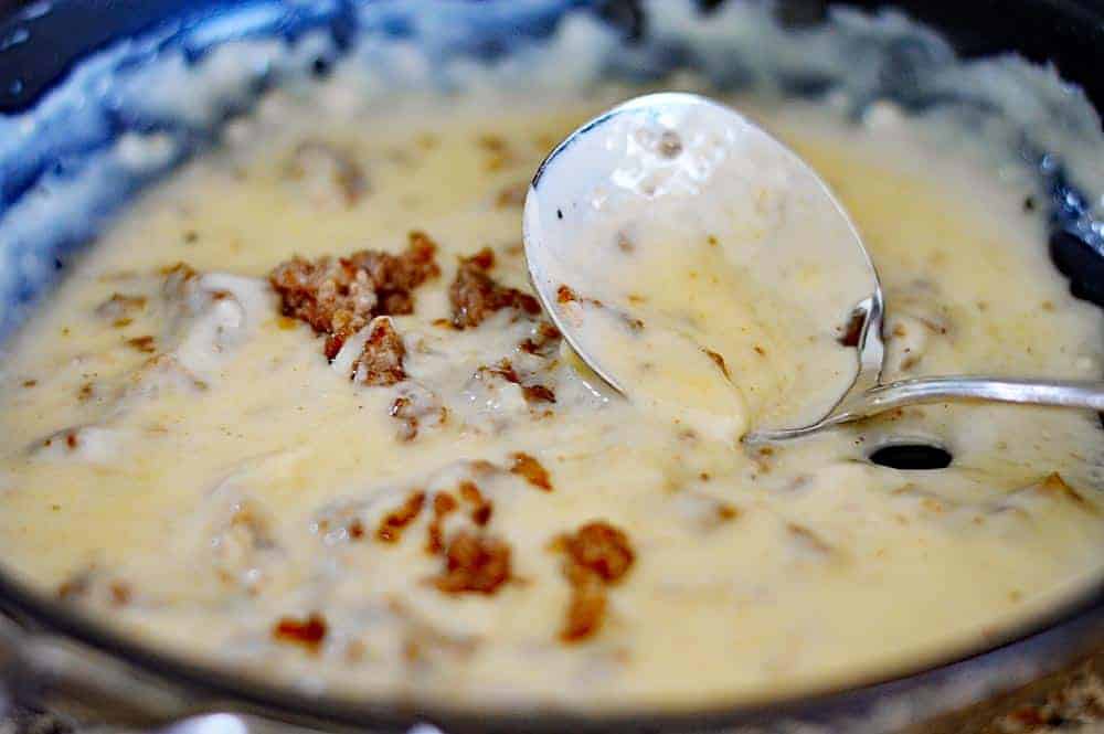 reheat oven to 450 degrees. In a large mixing bowl, combine flour, baking powder, baking soda and salt. Using your fingertips, rub butter and shortening into dry ingredients until mixture looks like crumbs. (The faster the better, you don't want the fats to melt.) Make a well in the center and pour in the chilled buttermilk. Stir just until the dough comes together. The dough will be very sticky. Turn dough onto floured surface, dust top with flour and gently fold dough over on itself 5 or 6 times. Press into a 1-inch thick round. Cut out biscuits with a 2-inch cutter, being sure to push straight down through the dough. Place biscuits on baking sheet so that they just touch. Reform scrap dough, working it as little as possible and continue cutting. Bake until biscuits are tall and light gold on top, 15 to 20 minutes While biscuits are baking cook sausage in a cast iron skillet. When done, remove sausage from pan and pour off all but 2 tablespoons of fat. Whisk flour into the fat and cook over low heat for 5 minutes. Remove pan from heat and whisk in milk a little at a time. Return to medium-high heat and stir occasionally while the gravy comes to a simmer and thickens. (Be sure to scrape up any brown bits that might be stuck to the bottom of the pan, that's where the flavor is.) Check seasoning, add crumbled sausage and serve over toast or biscuits.