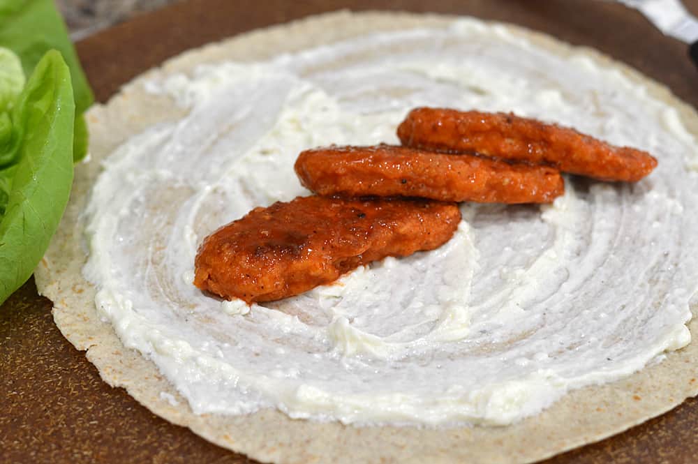 Layering Crispy Tenders on a Tortilla for Vegan Buffalo Crispy Tender Roll Ups