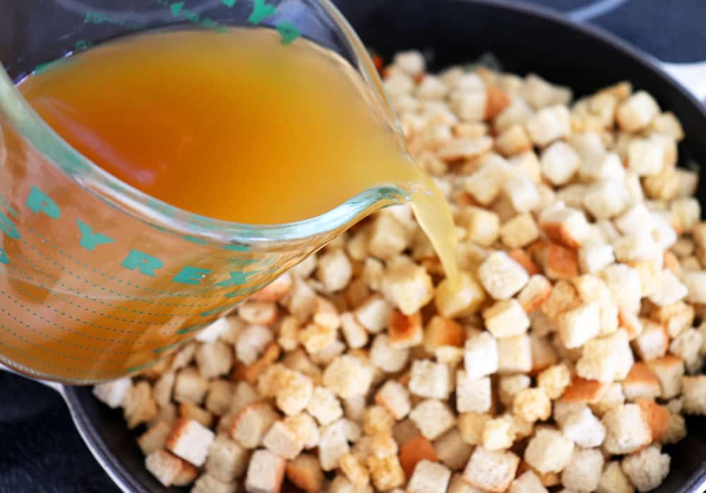Adding vegetable broth to the bread cubes