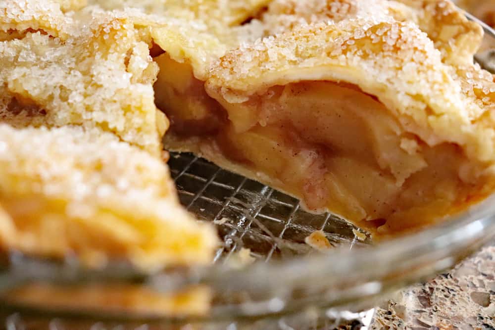 Whole apple pie with slice missing