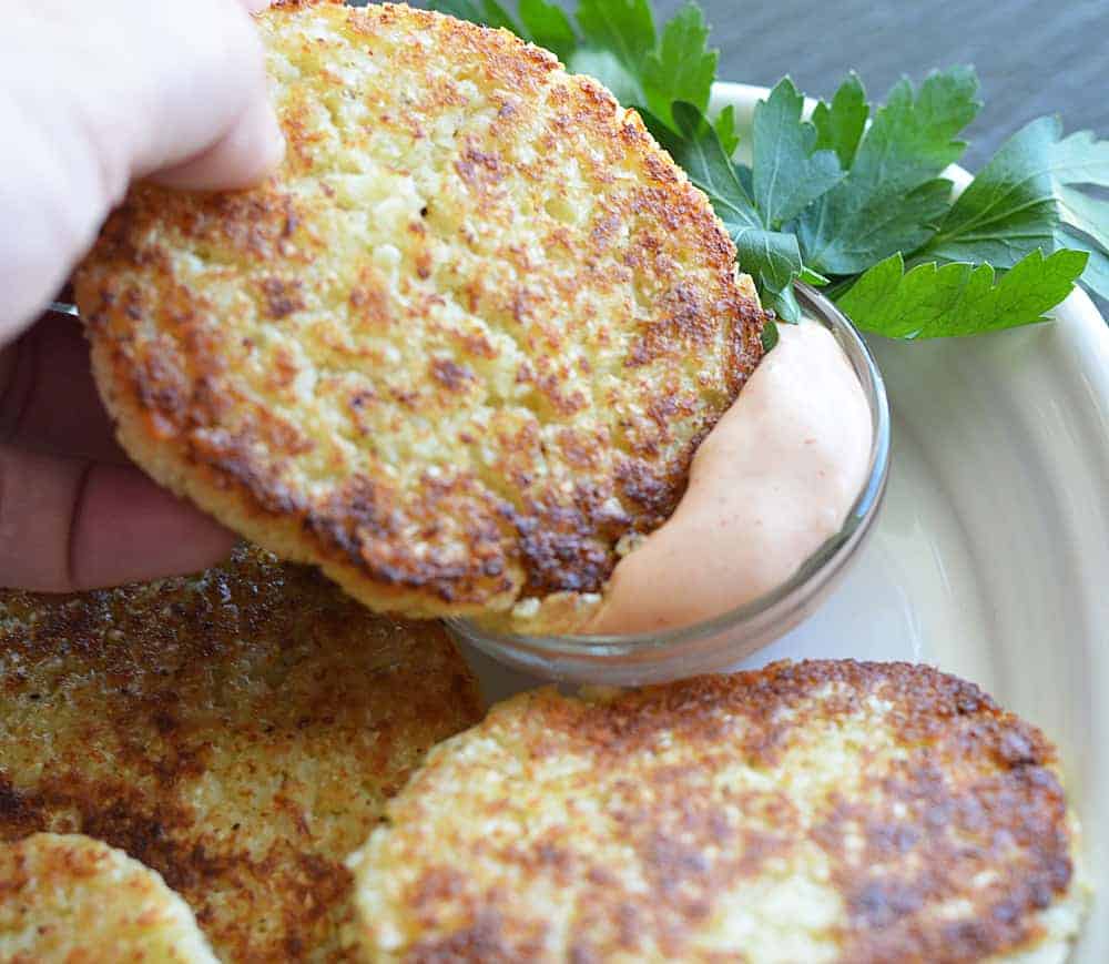 Dipping cauliflower fritter in to Copycat Outback Bloomin' Onion Sauce